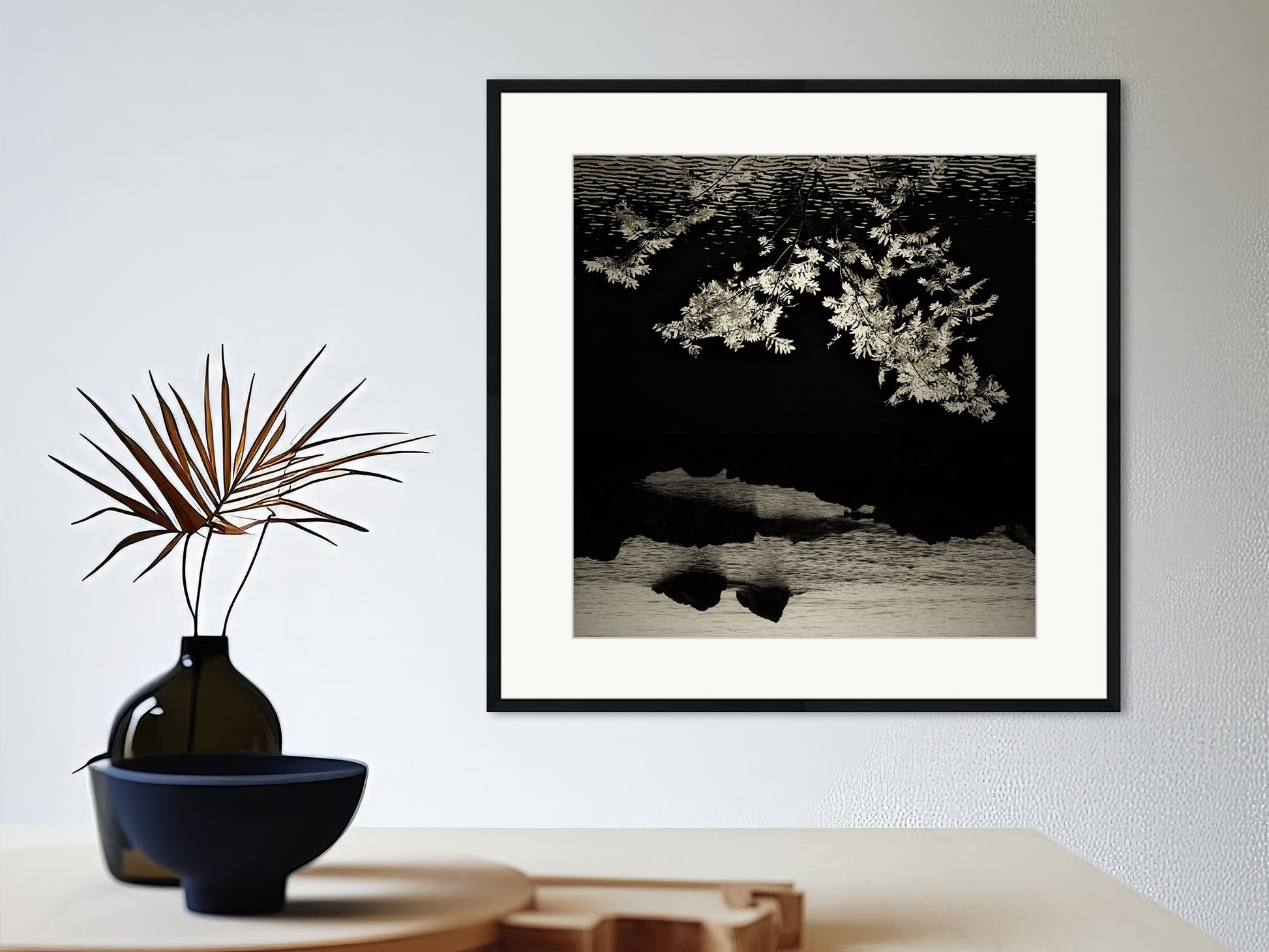 Soulscapes 3 by Andrea Christl, a mysterious black-and-white art photography print of an upside-down view of a branch, with a calm sea and rugged rocks in the background, framed with a passe-partout.